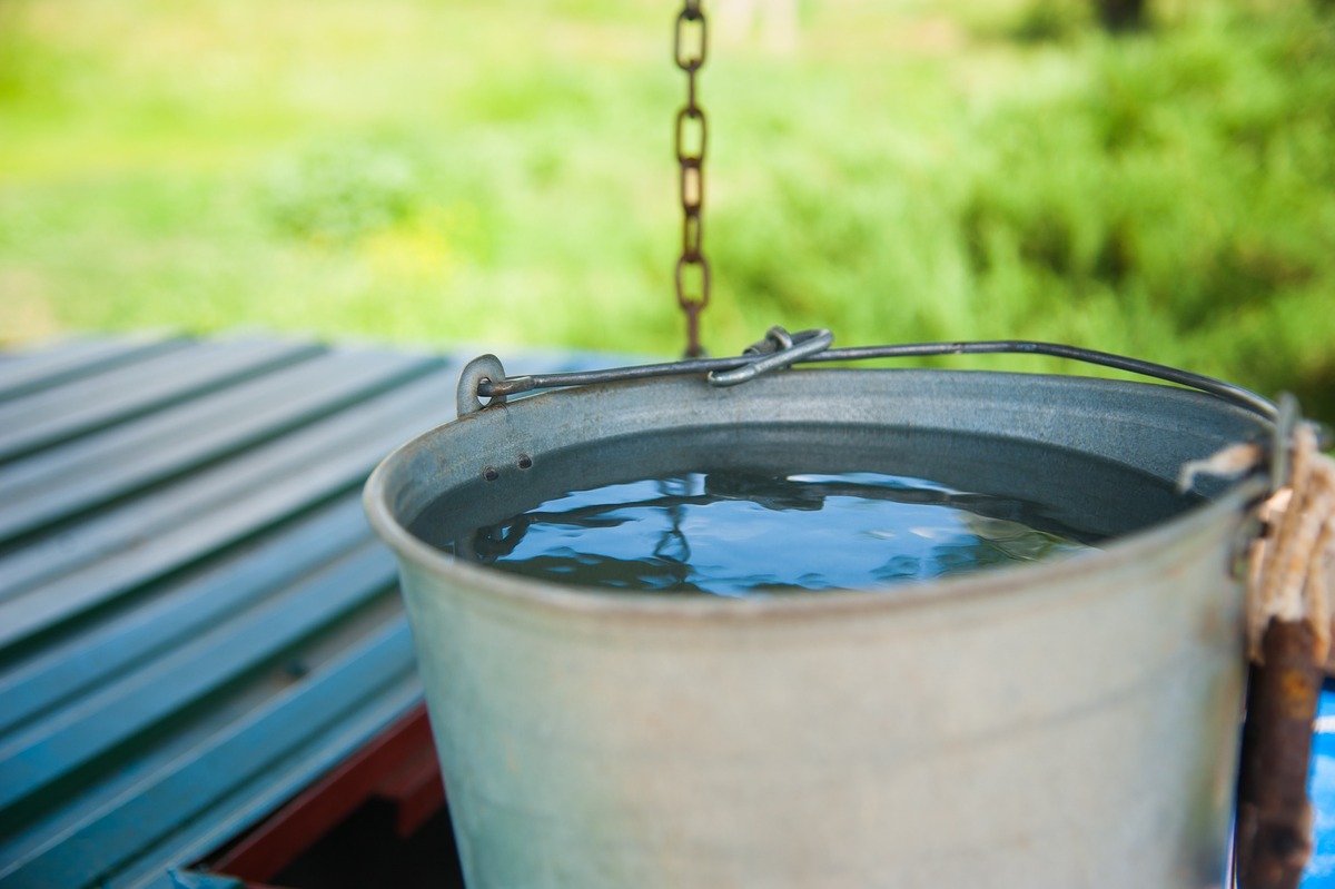 cubo con agua sobre tabla de madera